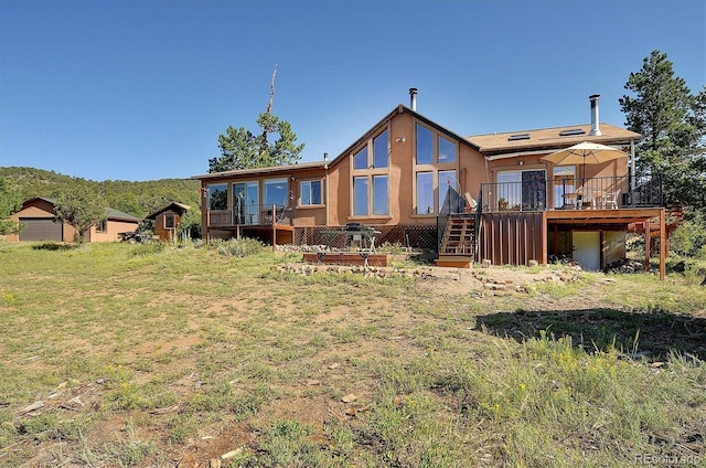 1111 Red Feather Rd, Cotopaxi, CO 81223 - back of house featuring a wooden deck, stairs, stucco siding, and a lawn