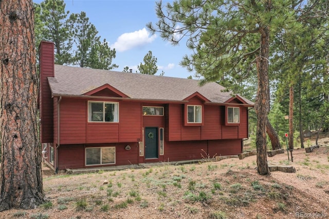 121 Aspen Dr, Woodland Park, CO 80863 - bi-level home featuring a chimney and roof with shingles