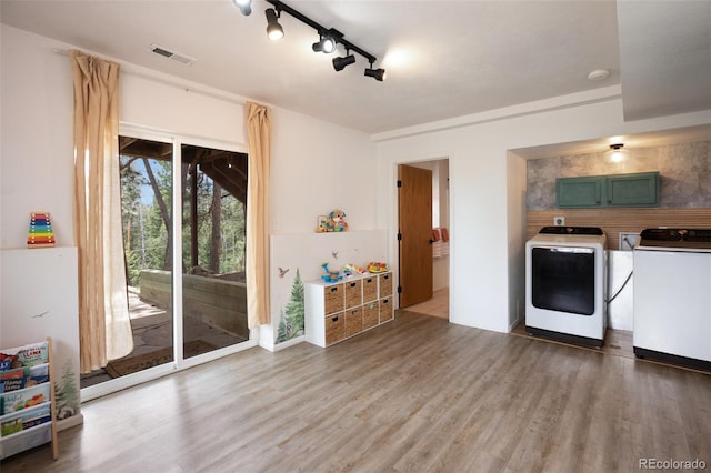 121 Aspen Dr, Woodland Park, CO 80863 - kitchen with washing machine and dryer, wood finished floors, track lighting, and green cabinetry