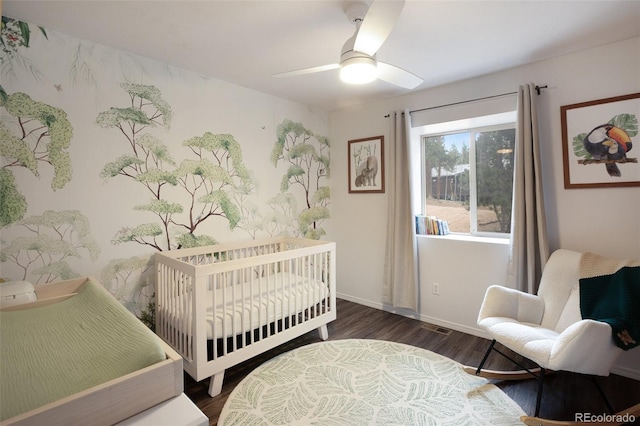 121 Aspen Dr, Woodland Park, CO 80863 - bedroom featuring dark wood finished floors, a crib, baseboards, and a ceiling fan