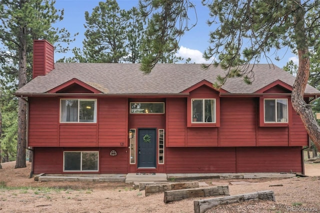 121 Aspen Dr, Woodland Park, CO 80863 - raised ranch featuring a chimney and roof with shingles