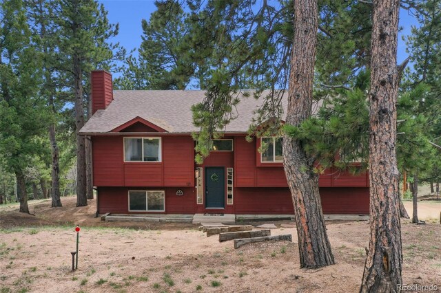 121 Aspen Dr, Woodland Park, CO 80863 - bi-level home featuring a chimney and roof with shingles