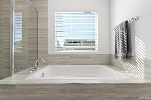 bathroom with a relaxing tiled tub