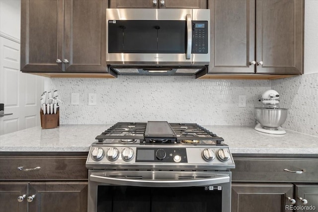 kitchen featuring dark brown cabinetry, stainless steel appliances, and backsplash