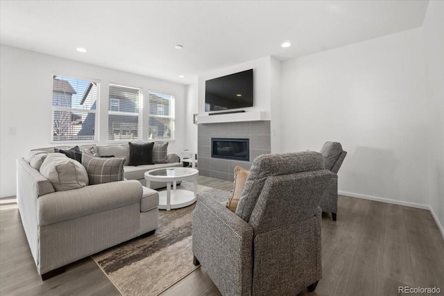 living room with a fireplace, recessed lighting, wood finished floors, and baseboards