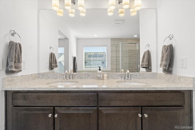 bathroom featuring a sink, double vanity, and a shower stall