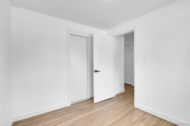 unfurnished bedroom featuring a closet and light hardwood / wood-style floors