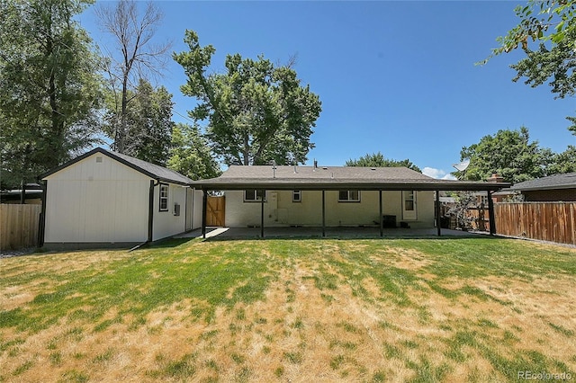 rear view of house with a lawn and a shed