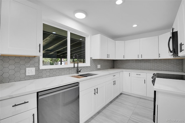 kitchen with light stone countertops, white cabinetry, dishwasher, and sink