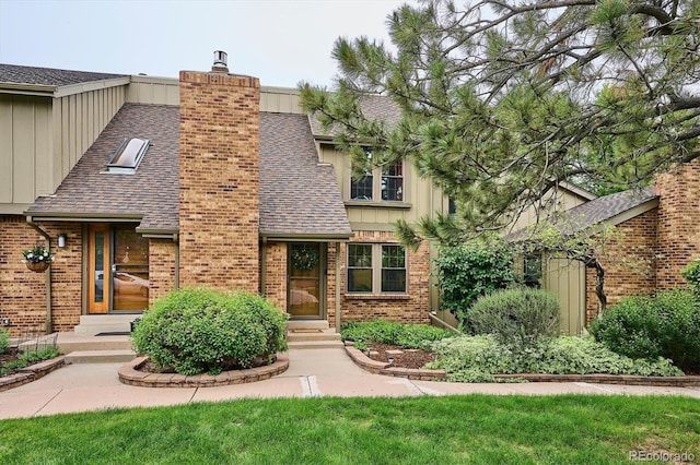 8170 E Phillips Cir, Centennial, CO 80112 - tudor-style house featuring brick siding, a chimney, roof with shingles, and board and batten siding