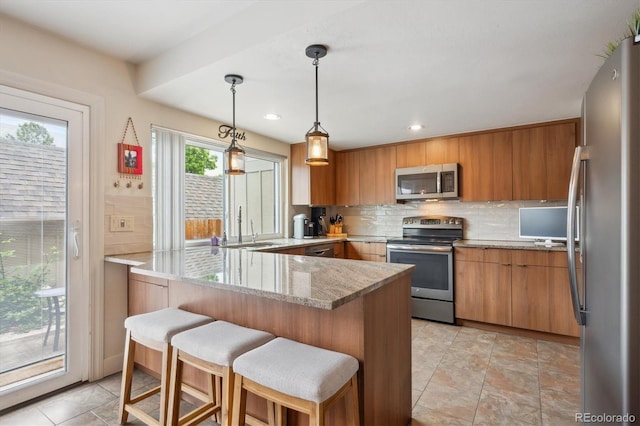 8170 E Phillips Cir, Centennial, CO 80112 - kitchen featuring appliances with stainless steel finishes, a sink, a peninsula, tasteful backsplash, and brown cabinets
