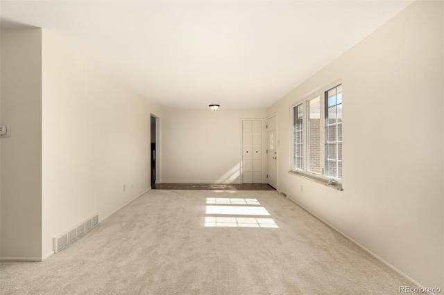 spare room featuring carpet floors and visible vents