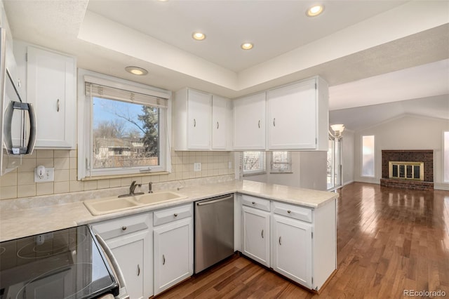 kitchen featuring dishwasher, range with electric stovetop, a sink, and white cabinetry