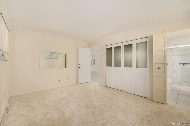 unfurnished bedroom featuring ornamental molding, a closet, carpet flooring, and connected bathroom