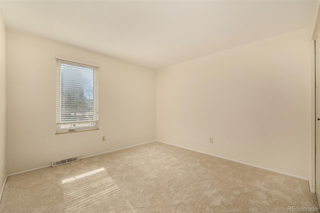 carpeted spare room featuring visible vents