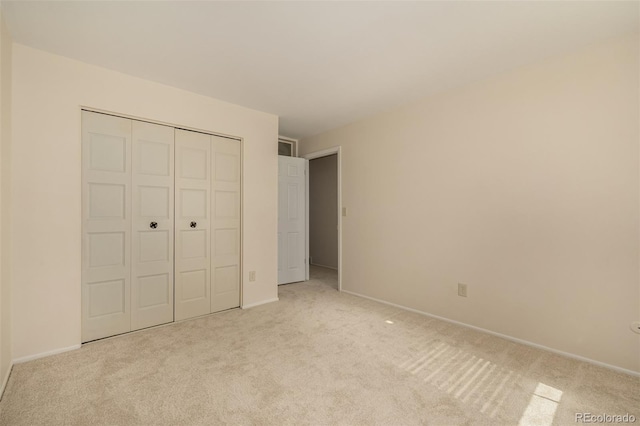 unfurnished bedroom with carpet, baseboards, and a closet