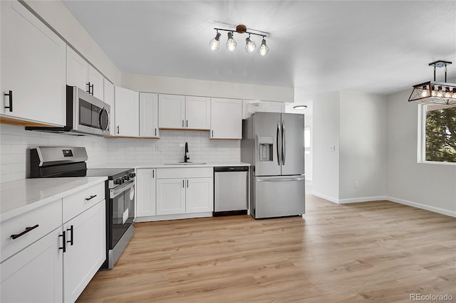 2503-2507 N Taft Ave, Loveland, CO 80538 - kitchen featuring stainless steel appliances, tasteful backsplash, light countertops, and light wood finished floors