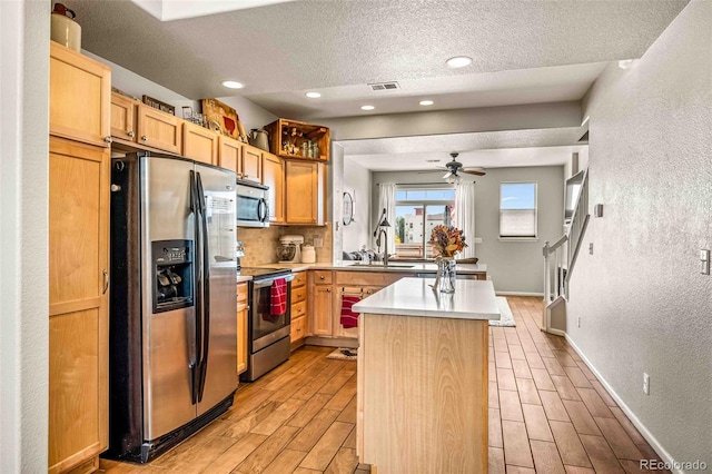 kitchen featuring visible vents, stainless steel appliances, light countertops, wood finish floors, and a sink