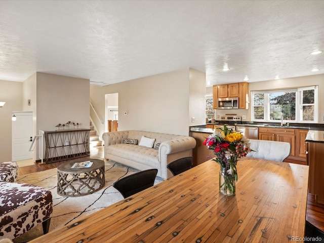 living area with light wood-style flooring and stairs