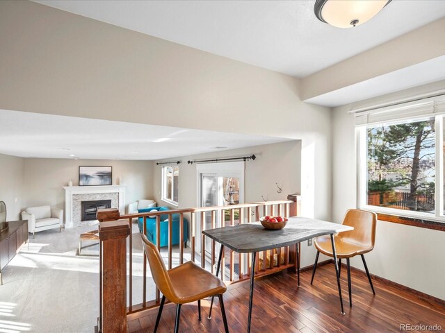 dining room featuring hardwood / wood-style flooring, baseboards, and a glass covered fireplace