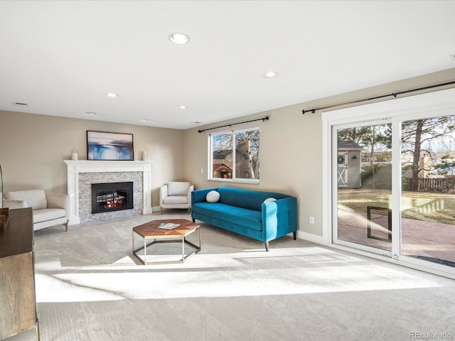 carpeted living area featuring a fireplace with flush hearth, recessed lighting, visible vents, and baseboards