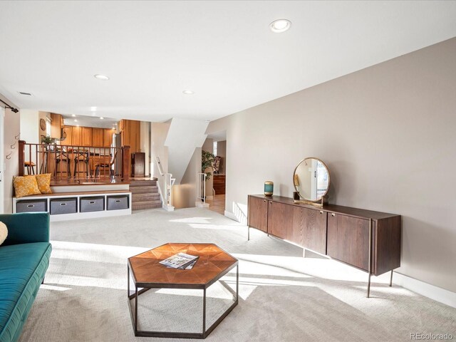 carpeted living room with stairs, baseboards, and recessed lighting