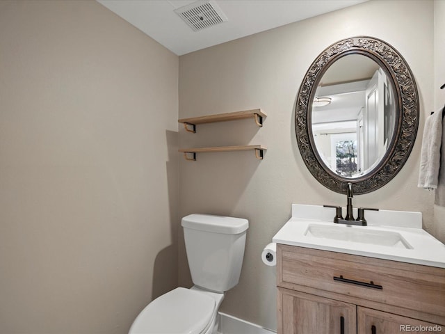 half bathroom with visible vents, vanity, and toilet