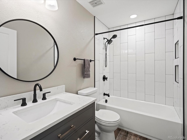 full bathroom featuring shower / bath combination, visible vents, toilet, wood finished floors, and vanity