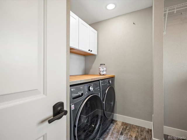 clothes washing area featuring cabinet space, baseboards, washer and dryer, and wood finish floors