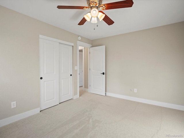 unfurnished bedroom featuring carpet floors, a closet, baseboards, and a ceiling fan