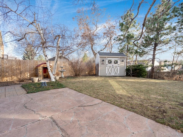 view of yard with a storage shed, a patio, an outbuilding, and a fenced backyard