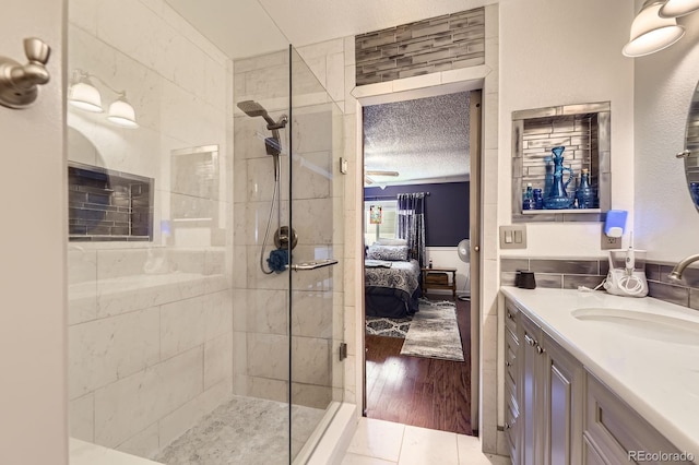 4054 S Olathe Ct, Aurora, CO 80013 - full bathroom with ensuite bathroom, walk in shower, vanity, wood finished floors, and a textured ceiling