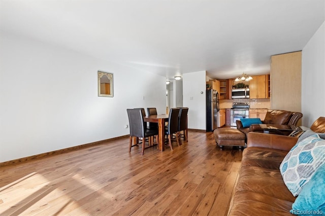 living room featuring light wood-type flooring and a chandelier