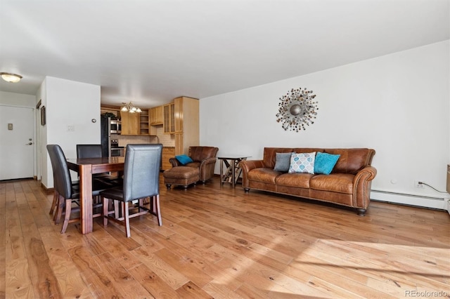 dining room with baseboard heating, an inviting chandelier, and light wood-type flooring