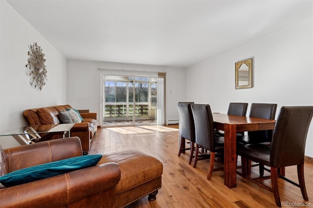 dining area with light wood-type flooring and a baseboard radiator