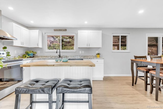 7727 W 81st Pl, Arvada, CO 80005 - kitchen featuring wall chimney exhaust hood, electric stove, a sink, recessed lighting, and light wood-type flooring
