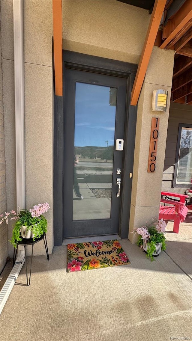 doorway to property featuring stucco siding