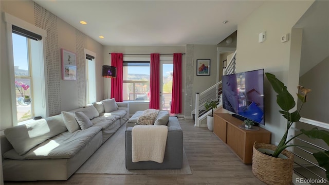 living room featuring plenty of natural light, recessed lighting, baseboards, and wood finished floors