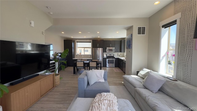 living area featuring visible vents, recessed lighting, and light wood-style flooring