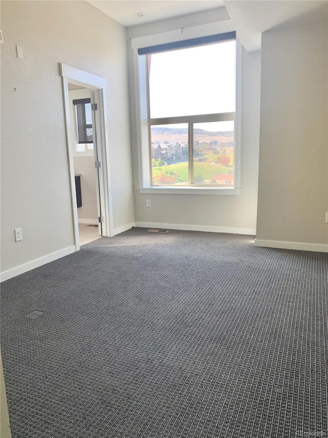carpeted empty room with baseboards