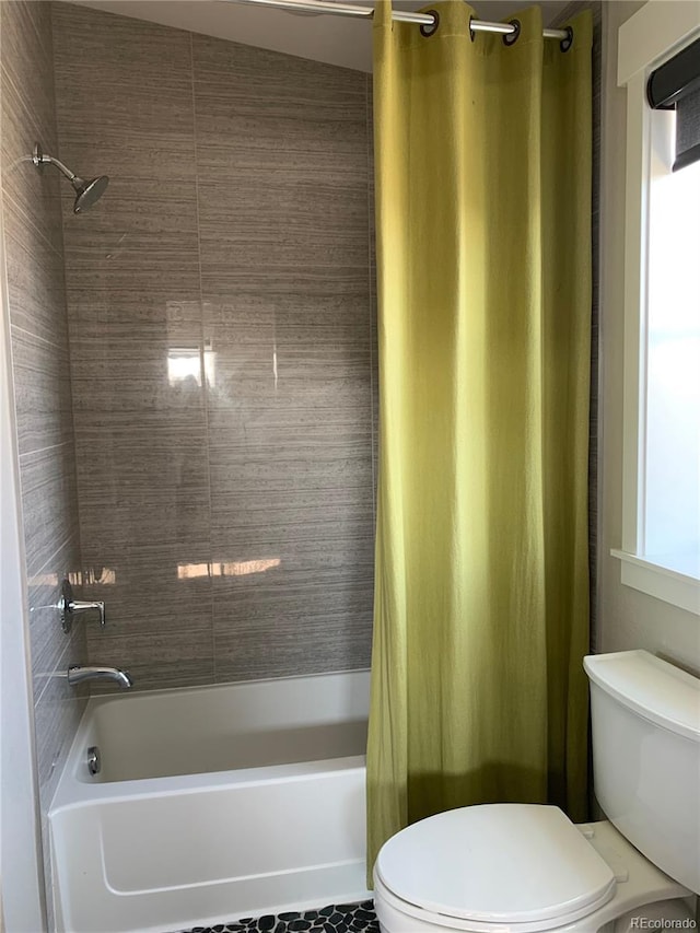 full bathroom with toilet and shower / bath combo with shower curtain