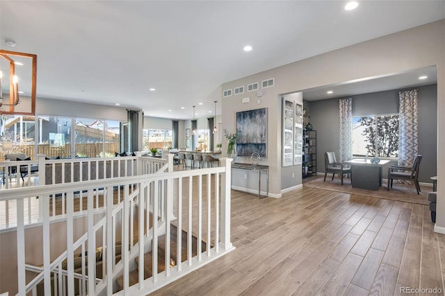 interior space with light hardwood / wood-style floors, sink, and an inviting chandelier