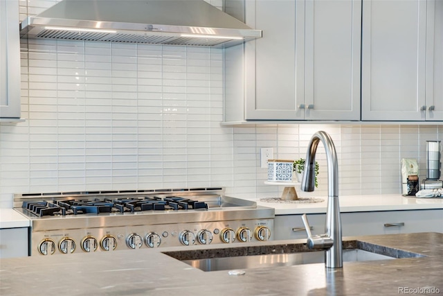 kitchen with wall chimney range hood and backsplash