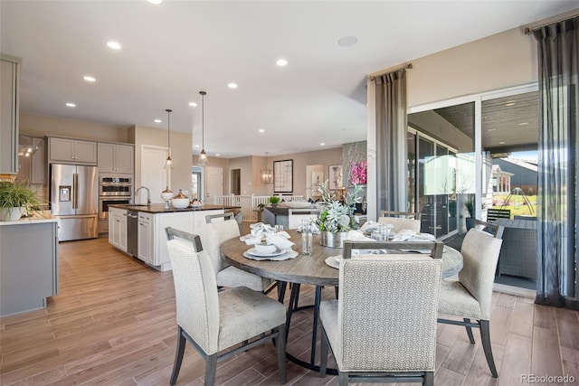 dining room with sink and light hardwood / wood-style flooring