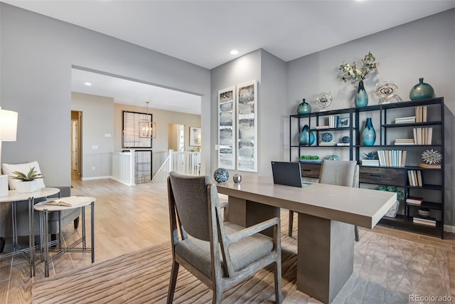 home office with light hardwood / wood-style floors and a chandelier