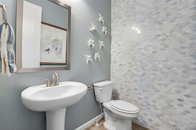 bathroom featuring hardwood / wood-style flooring, toilet, and sink