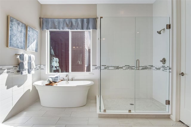 bathroom featuring independent shower and bath, tile patterned floors, and tile walls