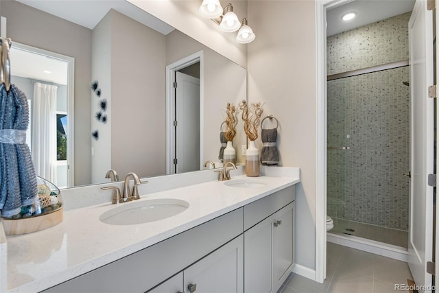 bathroom with vanity, tile patterned flooring, toilet, and a tile shower