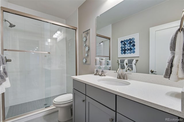 bathroom featuring toilet, an enclosed shower, and vanity