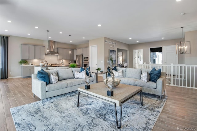 living room featuring light hardwood / wood-style flooring and an inviting chandelier